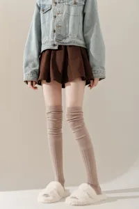 Detailopname van gezellige gebreide over-de-knie sokken in casual dagelijkse outfit.