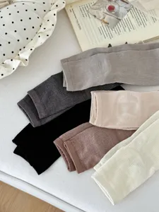 Detailed view of women's solid color ribbed socks and leg warmers in multiple versatile shades.