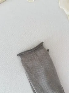 Detailed view of grey silk-like women's mid-tube socks, highlighting fine fabric and texture.