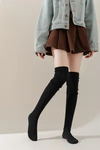 Detail van zwarte geribbelde overknee sokken voor dames, warme en comfortabele stijl.