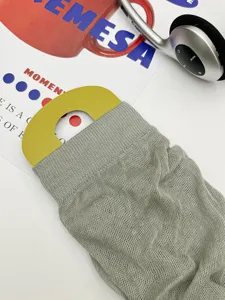 Detail view of grey knit mesh stirrup leg warmers, showing breathable texture and card.