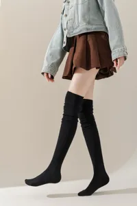 Gedetailleerd overzicht van zwarte dames overknee sokken van gebreid materiaal voor herfst en winter.