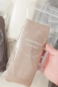 Detailopname van zachte, warme overknee stapelsokken in een transparante verpakking.