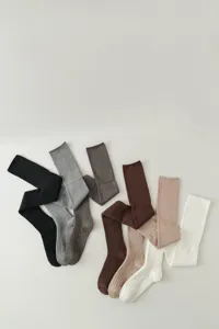 Gedetailleerd overzicht van lange gebreide kniekousen in diverse neutrale effen kleuren.