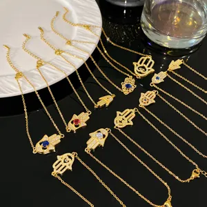 Détail de bracelets Hamsa plaqués or avec accents d'œil maléfique en zircon coloré