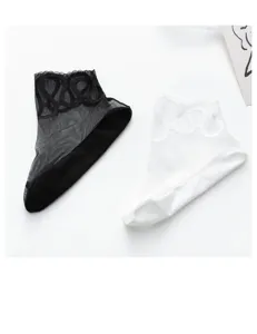 Close up detail of women thin lace mesh crystal silk socks in black and white colors.
