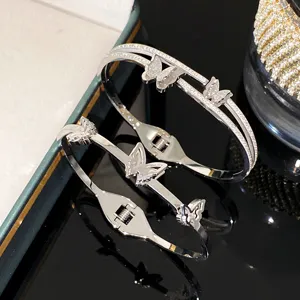 Detailed view of elegant silver butterfly bangles featuring pavé-set sparkling rhinestones.