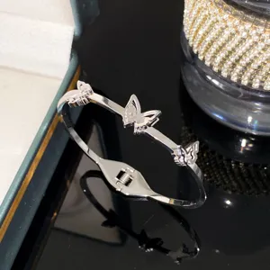 Detailed macro view of a silver titanium steel bangle featuring three elegant butterfly charms