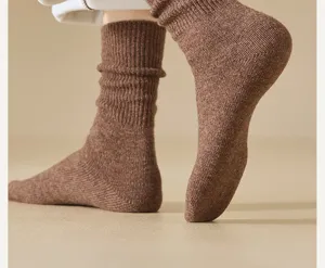 Close-up detail view of cozy brown wool winter slouch socks, showcasing soft knitted warm texture.