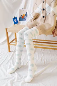 Detailed view of cozy fuzzy over-the-knee socks with cute polka dots for winter sleep.