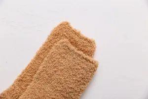 Detailopname van de textuur van dikke warme koraalfleece wintersokken voor thuis.