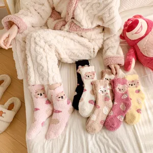 Closeup of cute fuzzy bear pattern socks in cozy bedroom scene with soft coral fleece texture.