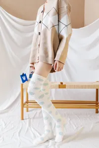 Cute polka dot over-the-knee coral fleece socks for women, cozy winter thermal sleep stockings.