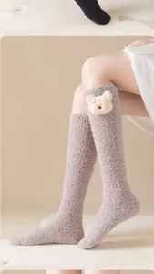Gros plan de chaussettes hautes en polaire douillette avec joli design d'ours en peluche, doux.