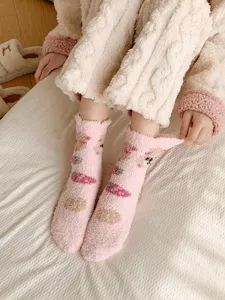 Close-up detail of cute pink fuzzy bear coral fleece socks, soft plush texture for winter.