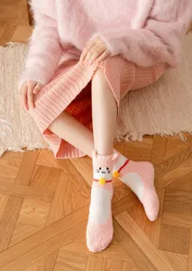 Close-up van schattige katten fleece sokken, zachte roze pluche textuur voor comfort thuis.