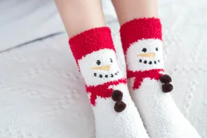 Close-up detail of fluffy Christmas snowman socks with cute 3D pom-poms for cozy winter wear.