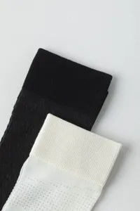 Detailed view of women thin mesh argyle knee high socks in classic black and white.