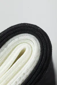 Detailed macro view of black and white layered mesh fabric rolls showing breathable texture.