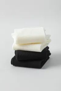Detailed close-up of folded black and white mesh calf socks with delicate pattern.