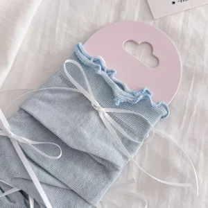 Scaldagambe in maglia azzurra stile balletto dolce con nastri a fiocco bianco moda estiva.