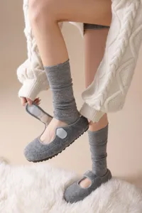 Detailed view of grey knit stirrup socks and casual flat shoes for cozy autumn style.