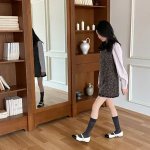 Vista di scena dettagliata di calze eleganti indossate da una modella in un interno in legno.