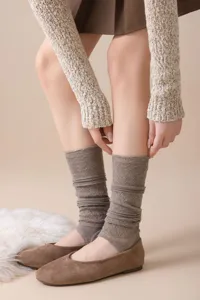 Details of brown knitted stirrup leg warmers with hollow-out diamond patterns for women.