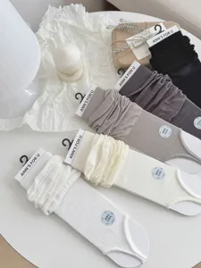 Detailweergave van effen moerbeizijde stirrup beenwarmers voor dames in verschillende kleuren.