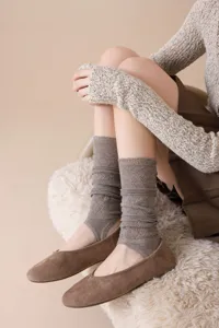 Ballet core knit stirrup leg warmers detail, soft wool blend fabric with elegant hollow-out pattern.