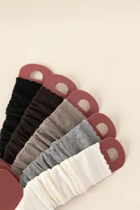 Close-up detail of soft knitted leg warmers in various colors, stylish cozy texture.