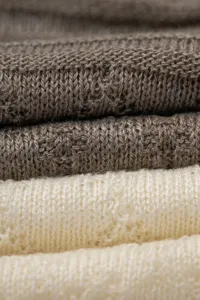 Close-up detail of fine wool knit fabric texture showing soft material layers clearly.