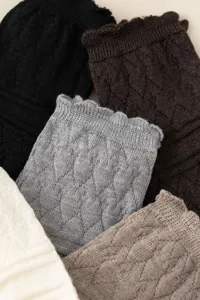 Detailed close-up of winter knitted stirrup leg warmers featuring cozy hollow mesh lace.