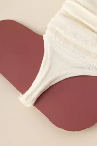 Close-up view of cream knitted foot stirrup socks, showcasing delicate hollow mesh and lace detail.