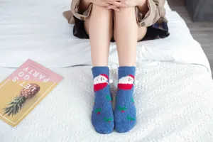 Close-up view of cozy blue fuzzy Christmas socks featuring cute Santa motif, soft sleep socks.