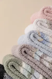 Primer plano de calcetines acogedores de forro polar coral a rayas, textura ultra suave, invierno.