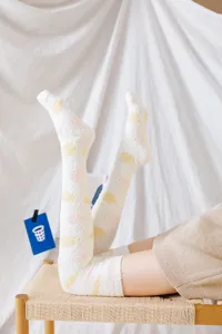 Detail shot of cozy fuzzy over-the-knee socks with cute dots for warm winter home sleep.