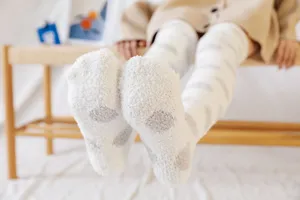 Cozy fuzzy over-the-knee socks detail, soft polka dot pattern for warm home wear.