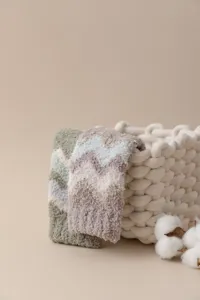 Vista detallada de calcetines de invierno a rayas de terciopelo coral con textura gruesa y suave.