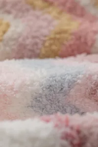 Detalle macro de calcetines de invierno de felpa coral a rayas, textura suave y muy cálida.