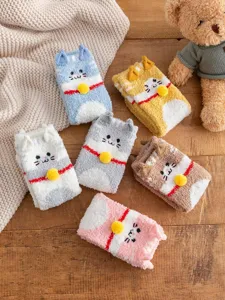 Detail van pluche katten sokken met zachte koraalfleece textuur en schattige oren.