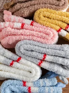 Gedetailleerde weergave van zachte fleece huissokken, warme slaapsokken op hout, winter.