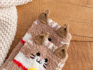 Close-up detail van pluche koraalvlies sokken met schattige 3D kattenoren en fijne borduursels.