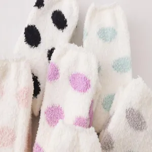 Close-up detail shot of soft fuzzy coral fleece polka dot socks for cozy autumn winter.