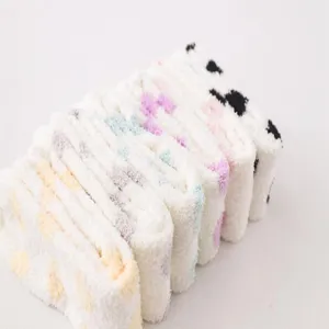 Close-up detail shot of cozy fluffy coral fleece knee-high socks with cute polka dots.