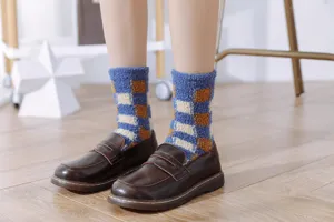 Cozy blue and orange checkered fuzzy socks detail close-up, soft coral fleece knit texture.