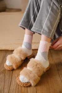 Detailed view of cozy fluffy coral fleece socks and plush home slippers for winter warmth.