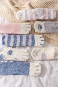 Close-up view of cozy fuzzy fleece socks featuring cute cat paw prints and soft striped details.