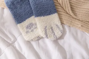 Cozy coral fleece fuzzy socks detail, soft plush winter sleep socks with cute paw design.