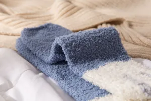 Detailed view of fluffy coral fleece winter socks, soft cozy texture for home sleep.